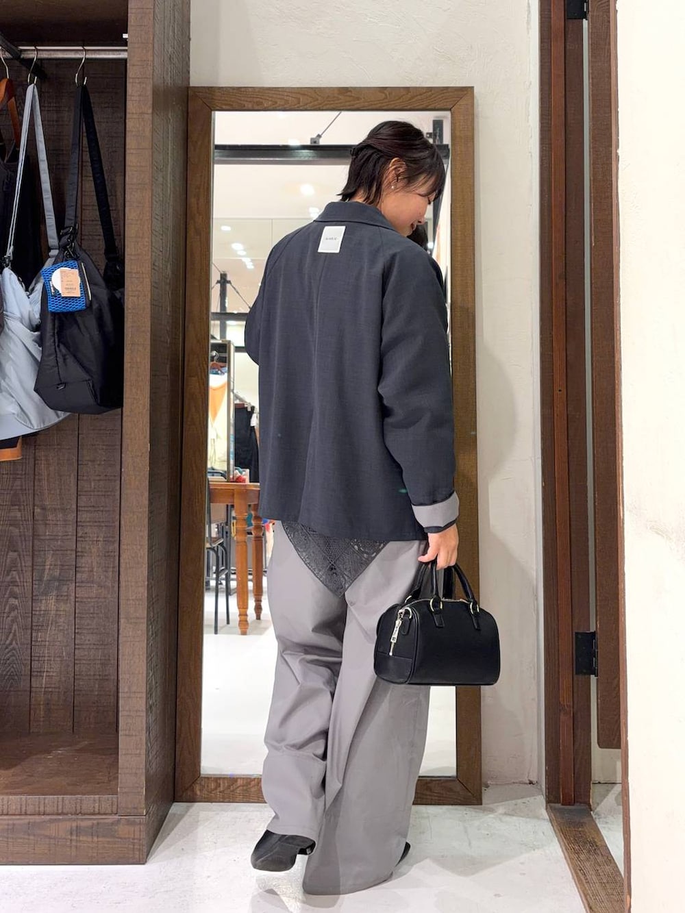 ブラック系のボストンバッグ、グレー系のシャツ/ブラウス、イエロー系のネックレスを着用したレディースの冬コーディネートの4枚目の写真