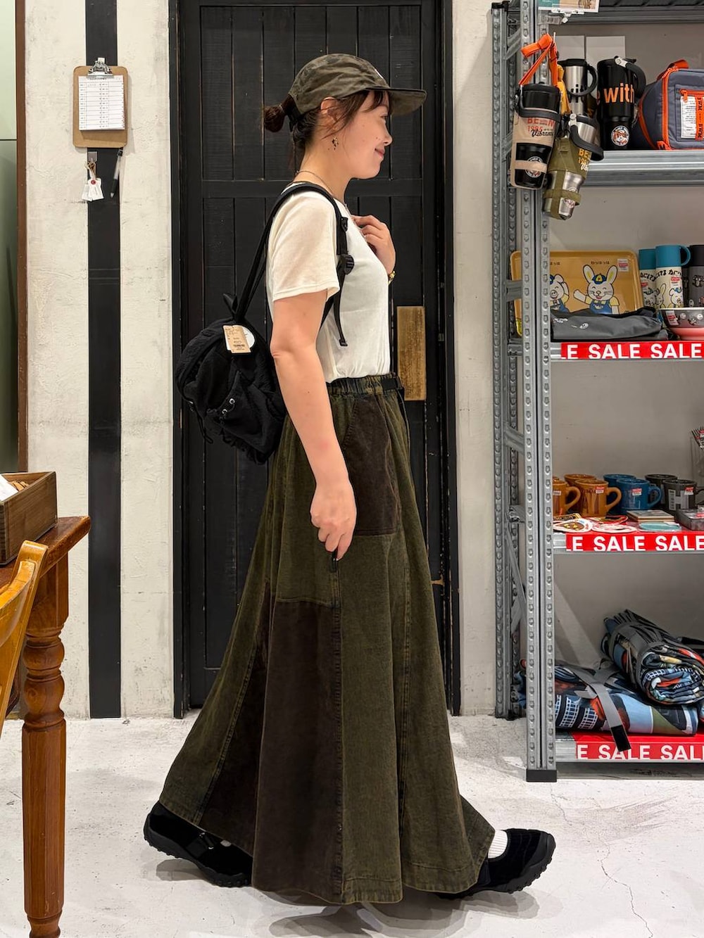 ブラック系のバレエシューズ、ブラック系のバックパック/リュック、ベージュ系のTシャツ/カットソーを着用したレディースの夏コーディネートの5枚目の写真