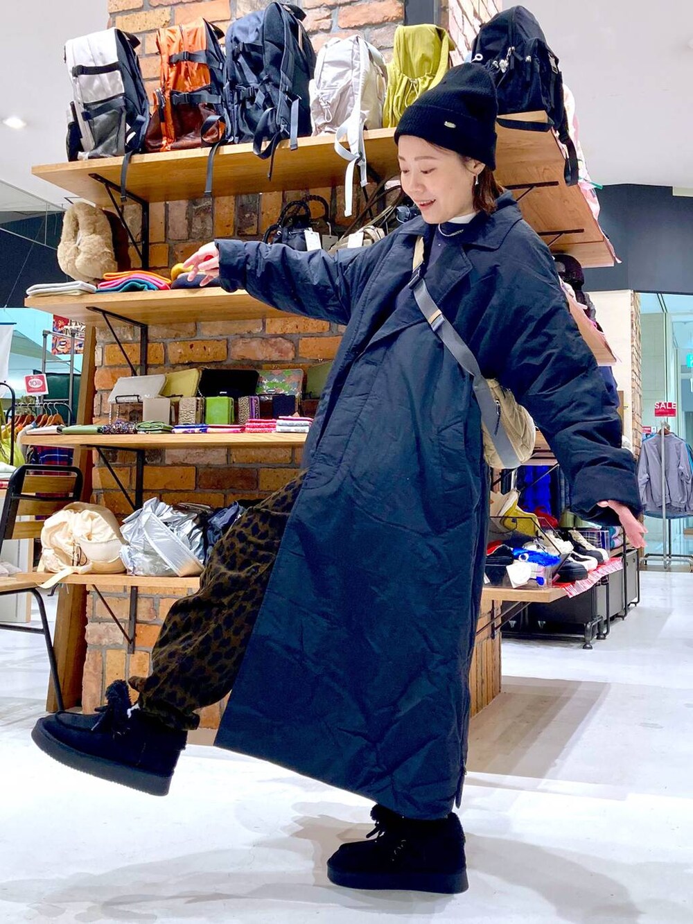 ベージュ系のショルダーバッグ、ホワイト系のTシャツ/カットソー、ブラック系のモカシン/デッキシューズを着用したレディースの冬コーディネートの2枚目の写真