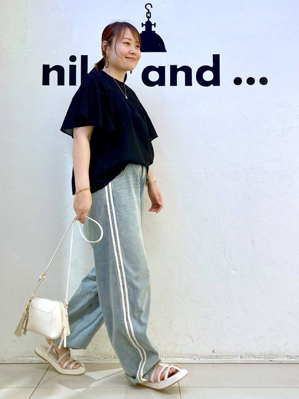 ベージュ系のサンダル、ブラウン系のショルダーバッグ、ブラック系のシャツ/ブラウスを着用したレディースの夏コーディネートの4枚目の写真