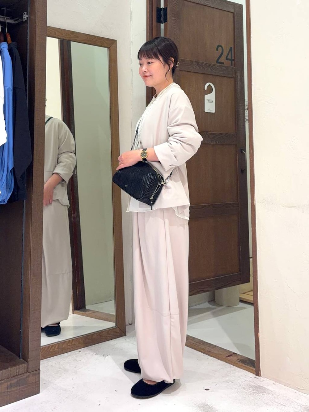 ブラック系のパンプス、ホワイト系のシャツ/ブラウス、その他のショルダーバッグを着用したレディースの冬コーディネートの6枚目の写真