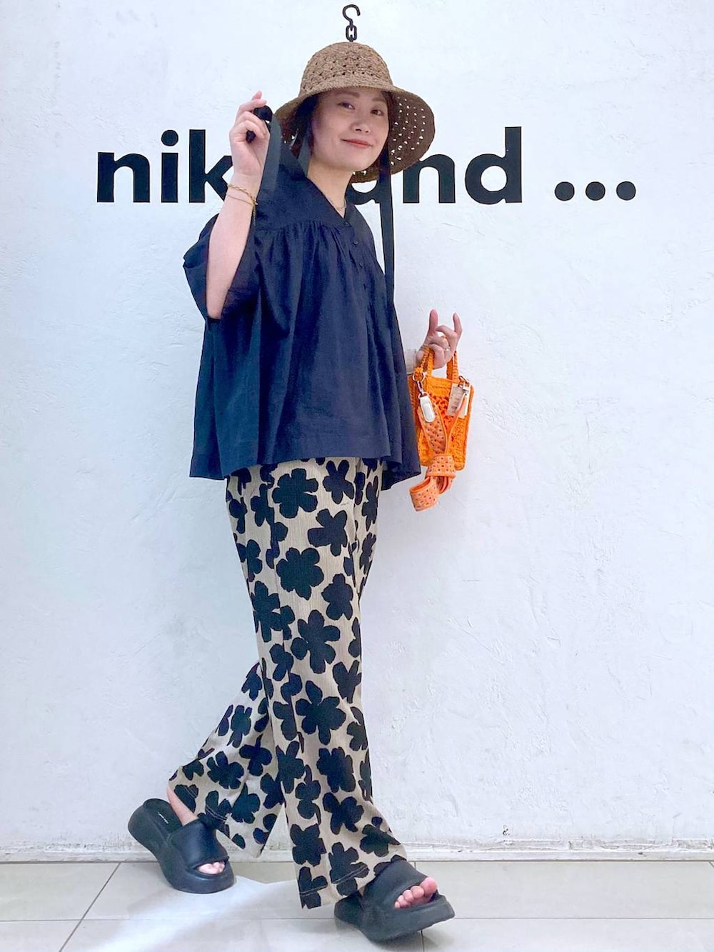 オレンジ系のショルダーバッグ、ブラック系のサンダル、その他のTシャツ/カットソーを着用したレディースの春コーディネートの3枚目の写真