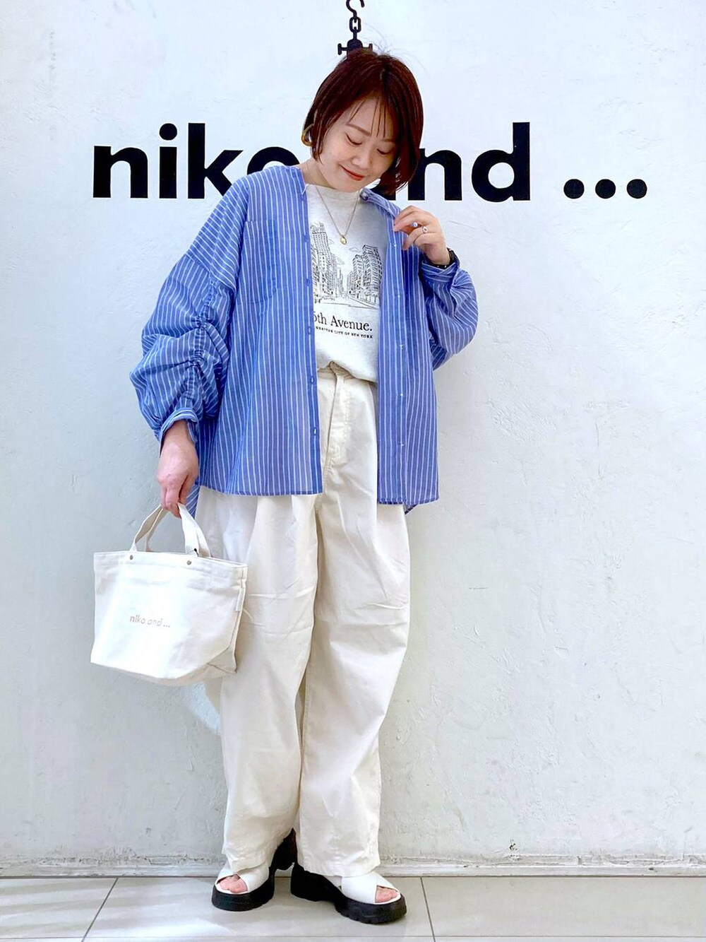 ホワイト系のサンダル、ベージュ系のTシャツ/カットソー、ホワイト系のトートバッグを着用したレディースの春コーディネートの2枚目の写真