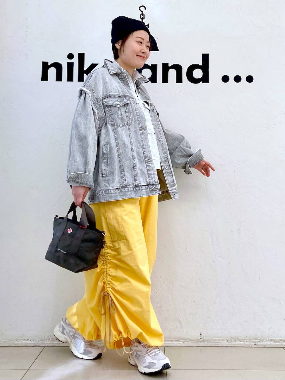 ベージュ系のスウェット、グレー系のデニムジャケット、ホワイト系のスニーカーを着用したレディースの冬コーディネートの3枚目の写真