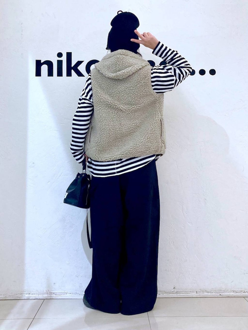 ベージュ系のベスト、ブラック系のその他パンツ、ブラック系のショルダーバッグを着用したレディースの冬コーディネートの4枚目の写真