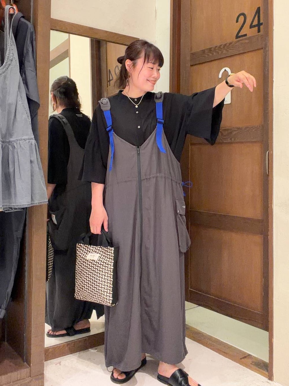 ブラック系のトートバッグを着用したレディースの夏コーディネートの2枚目の写真
