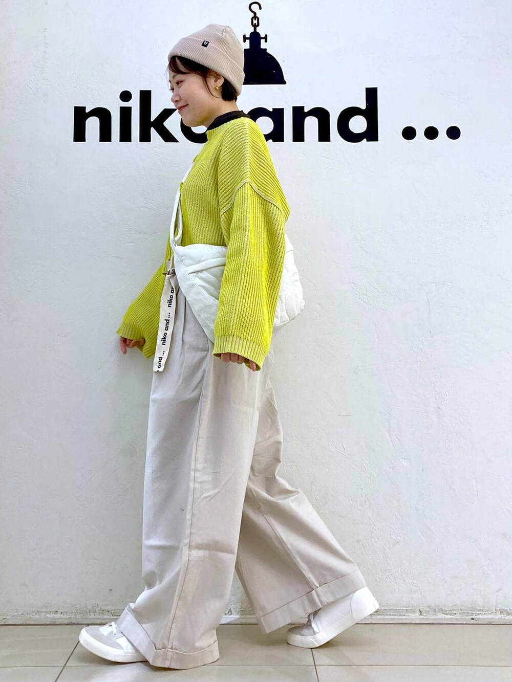 ベージュ系のその他パンツ、イエロー系のニット/セーター、ホワイト系のスニーカーを着用したレディースの冬コーディネートの3枚目の写真