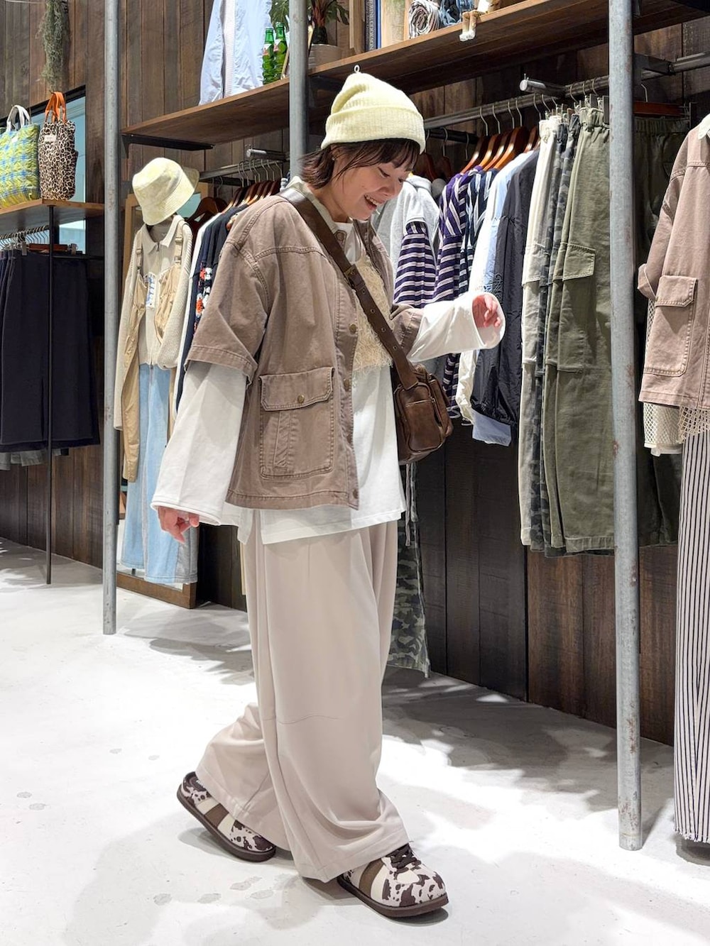 ブラウン系のショルダーバッグ、ベージュ系のベスト、ホワイト系のTシャツ/カットソーを着用したレディースの春コーディネートの3枚目の写真