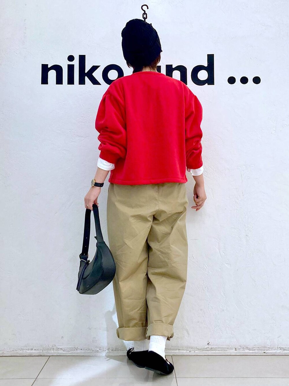 ブラック系のショルダーバッグ、ブラック系のパンプス、イエロー系のチノパンツを着用したレディースの冬コーディネートの3枚目の写真