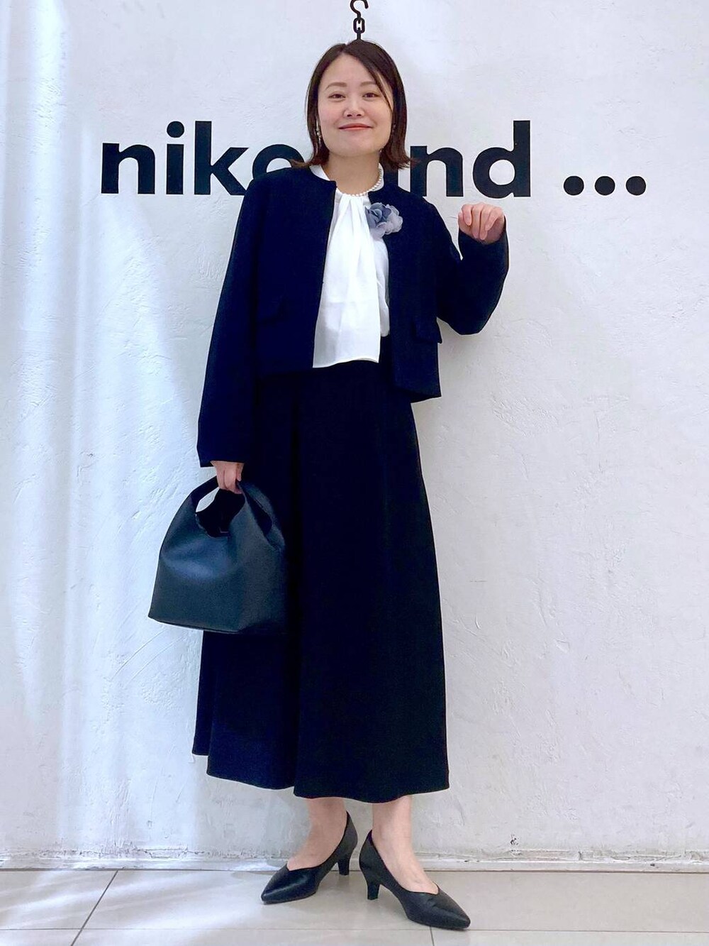 ホワイト系のシャツ/ブラウス、ブラック系のパンプス、ブラック系のノーカラージャケットを着用したレディースの冬コーディネートの3枚目の写真