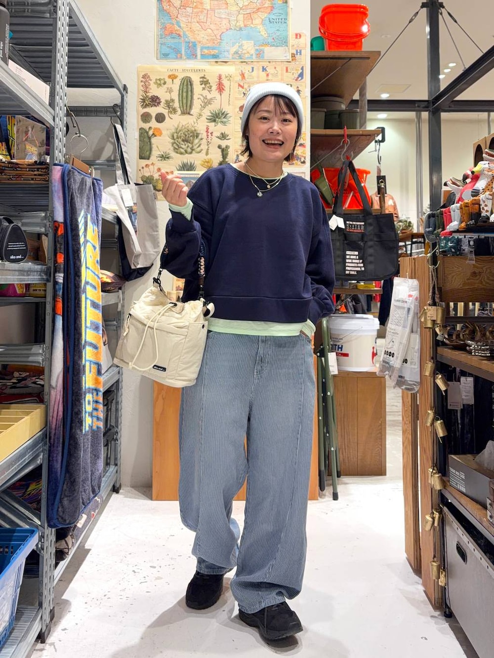 ブルー系のデニムパンツ、ブルー系のスウェット、ベージュ系のショルダーバッグを着用したレディースの冬コーディネートの2枚目の写真