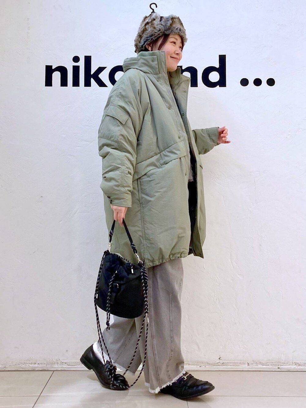 グリーン系のブルゾン、ホワイト系のTシャツ/カットソー、グレー系のその他パンツを着用したレディースの冬コーディネートの4枚目の写真