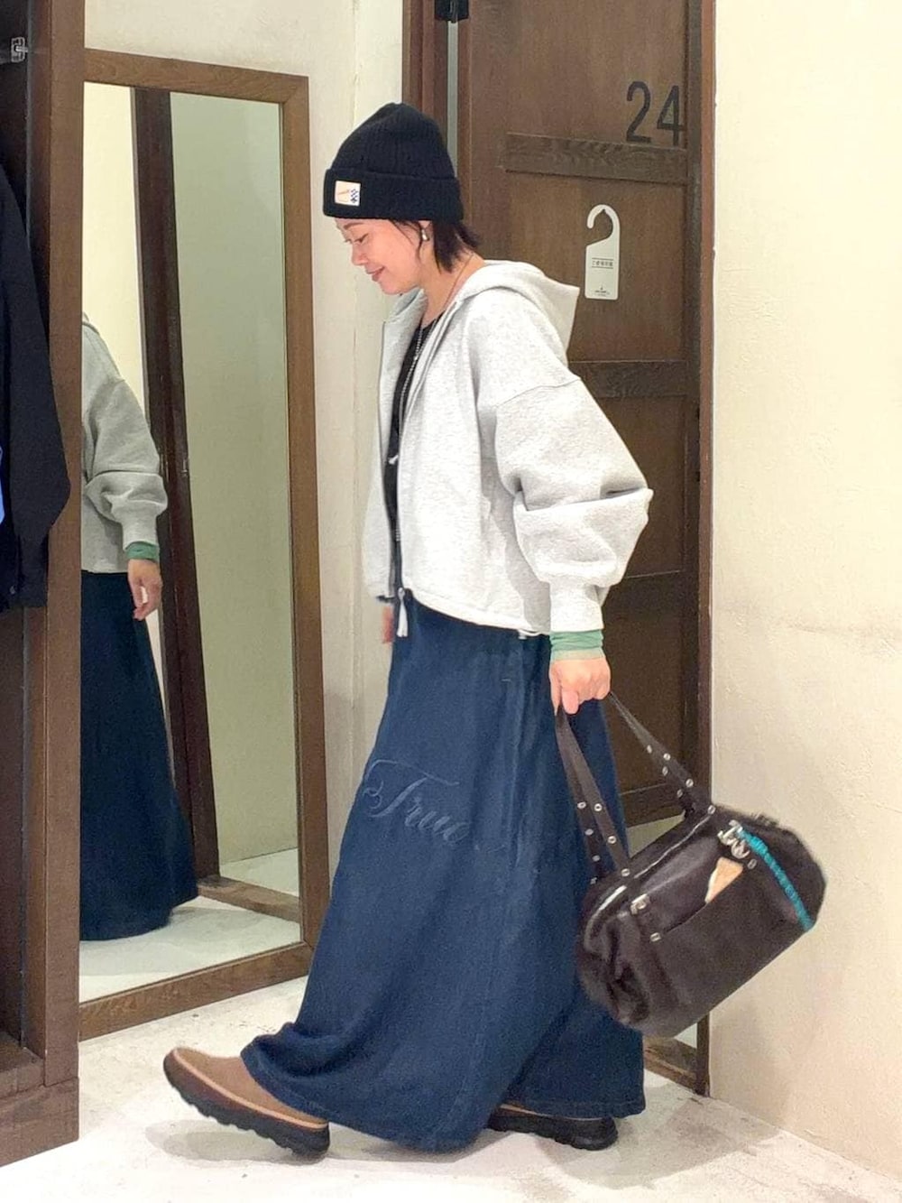 ブラウン系のボストンバッグ、ブラック系のTシャツ/カットソー、グレー系のパーカーを着用したレディースの春コーディネートの5枚目の写真