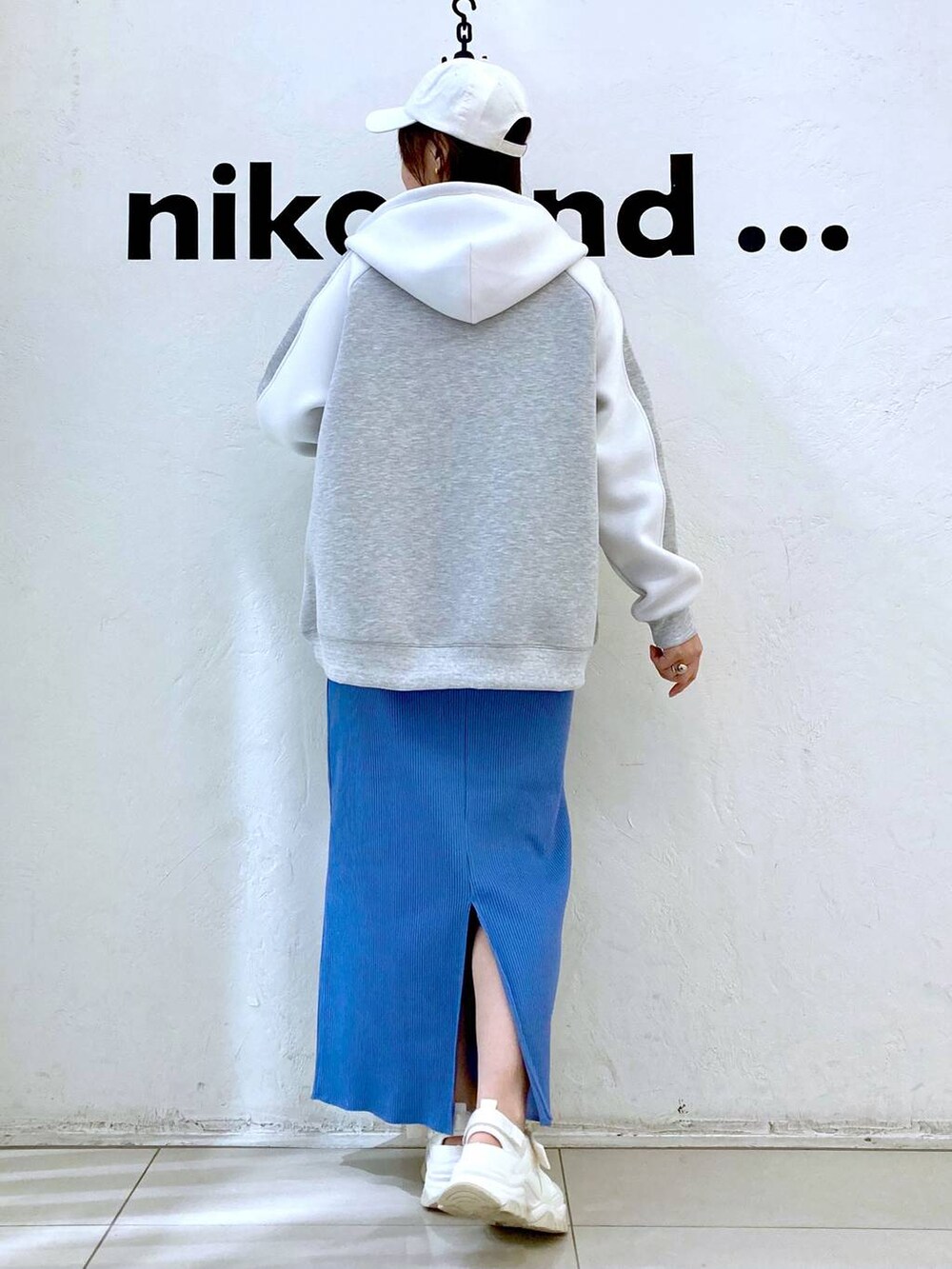 ベージュ系のTシャツ/カットソー、ベージュ系のスニーカー、ブルー系のスカートを着用したレディースの冬コーディネートの4枚目の写真