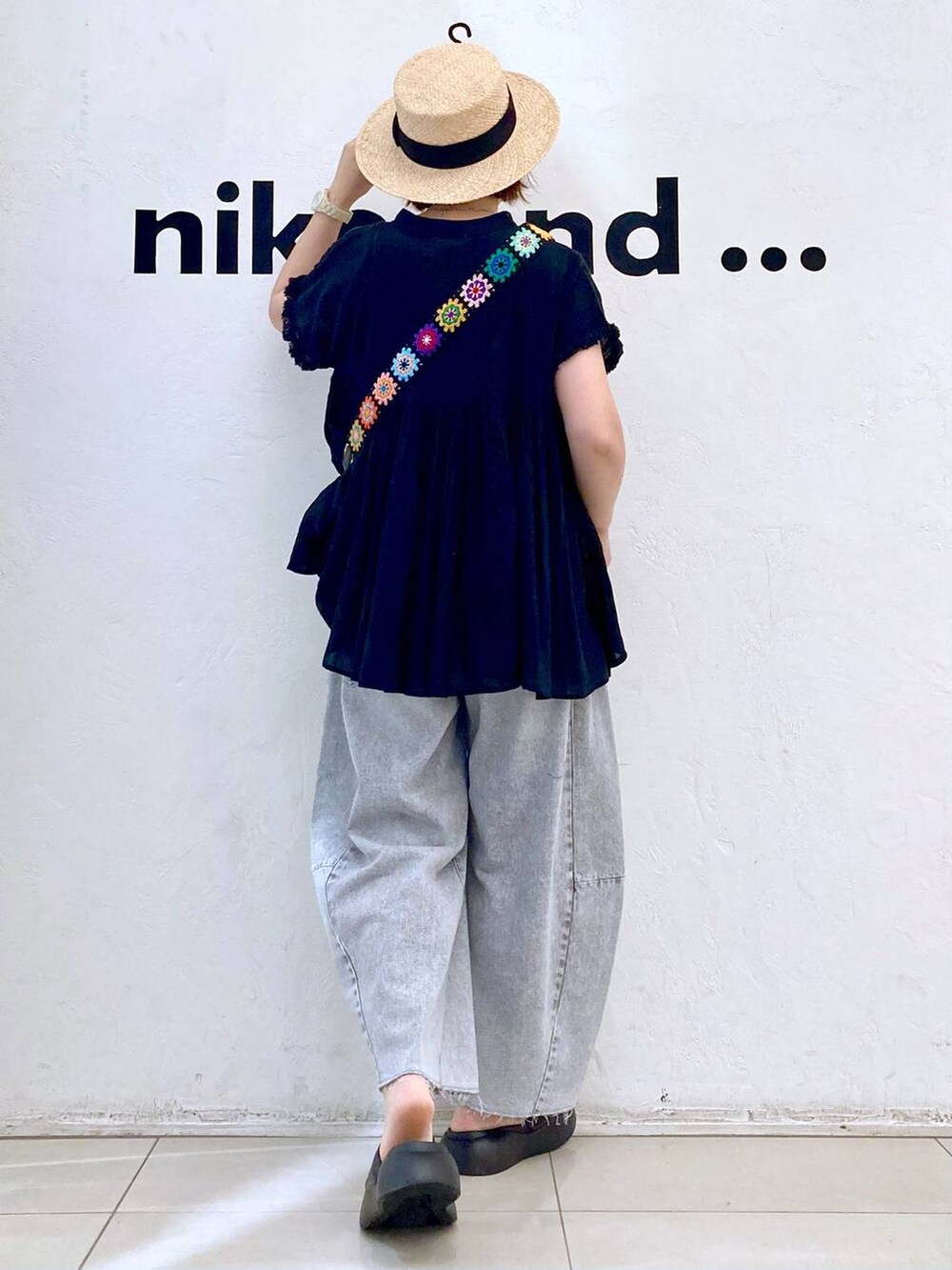 ブラック系のショルダーバッグ、ブラック系のサンダル、グレー系のデニムパンツを着用したレディースの春コーディネートの4枚目の写真