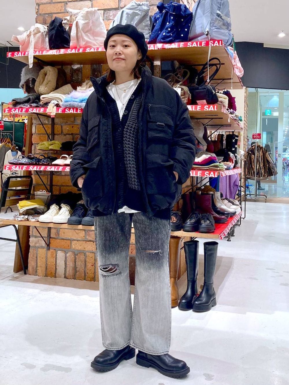 ブラック系のブルゾン、ブラック系のデニムパンツ、ホワイト系のTシャツ/カットソーを着用したレディースの冬コーディネートの3枚目の写真