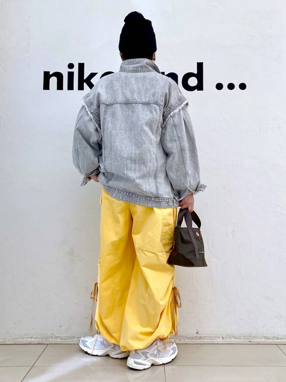 ベージュ系のスウェット、グレー系のデニムジャケット、ホワイト系のスニーカーを着用したレディースの冬コーディネートの4枚目の写真