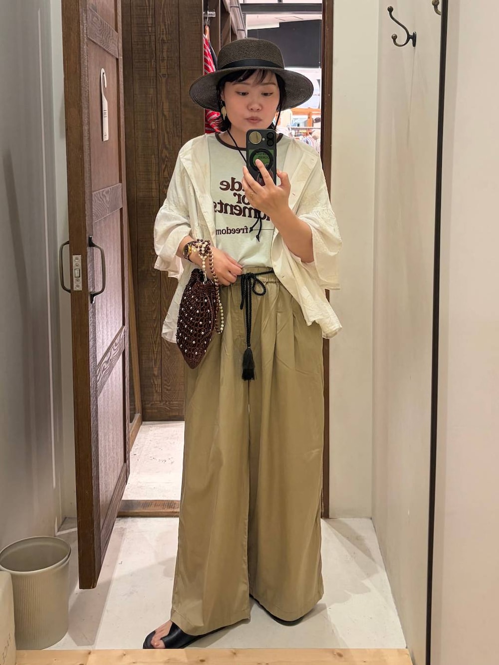 ベージュ系のその他パンツ、ホワイト系のシャツ/ブラウス、ブラウン系のショルダーバッグを着用したレディースの春コーディネートの2枚目の写真