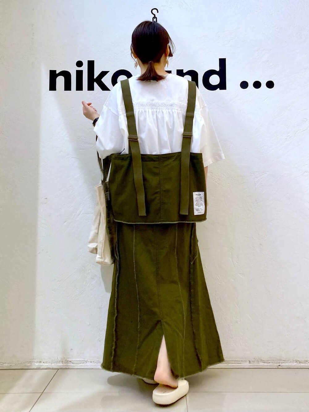 ベージュ系のトートバッグ、ベージュ系のサンダル、ホワイト系のTシャツ/カットソーを着用したレディースの春コーディネートの4枚目の写真