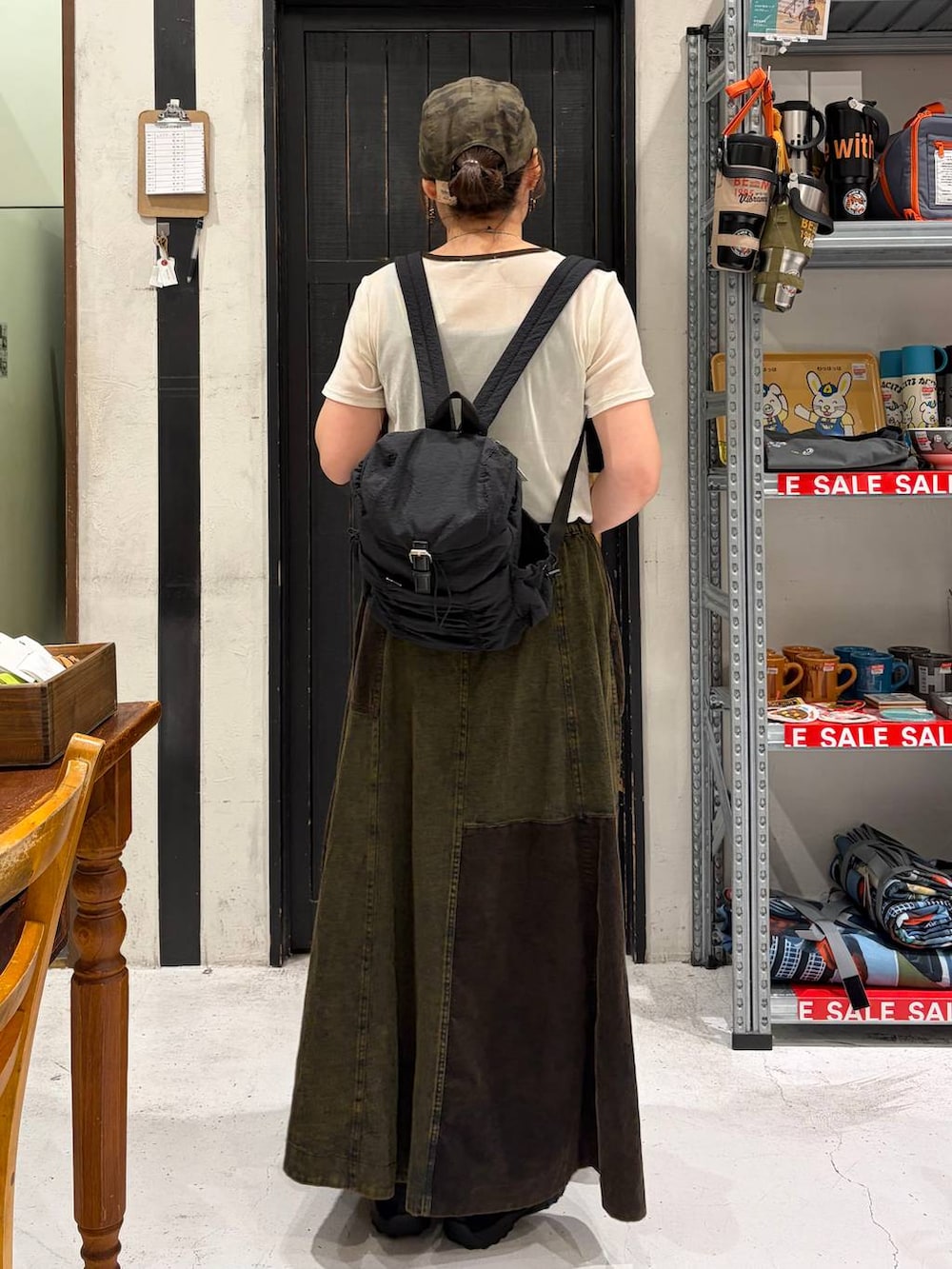 ブラック系のバレエシューズ、ブラック系のバックパック/リュック、ベージュ系のTシャツ/カットソーを着用したレディースの夏コーディネートの4枚目の写真