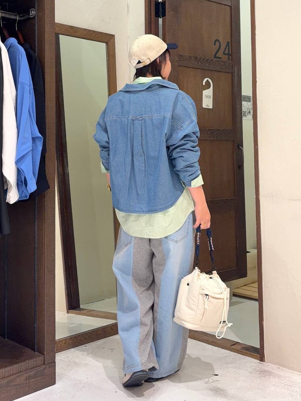 グレー系のデニムパンツ、グリーン系のシャツ/ブラウス、ベージュ系のショルダーバッグを着用したレディースの春コーディネートの4枚目の写真