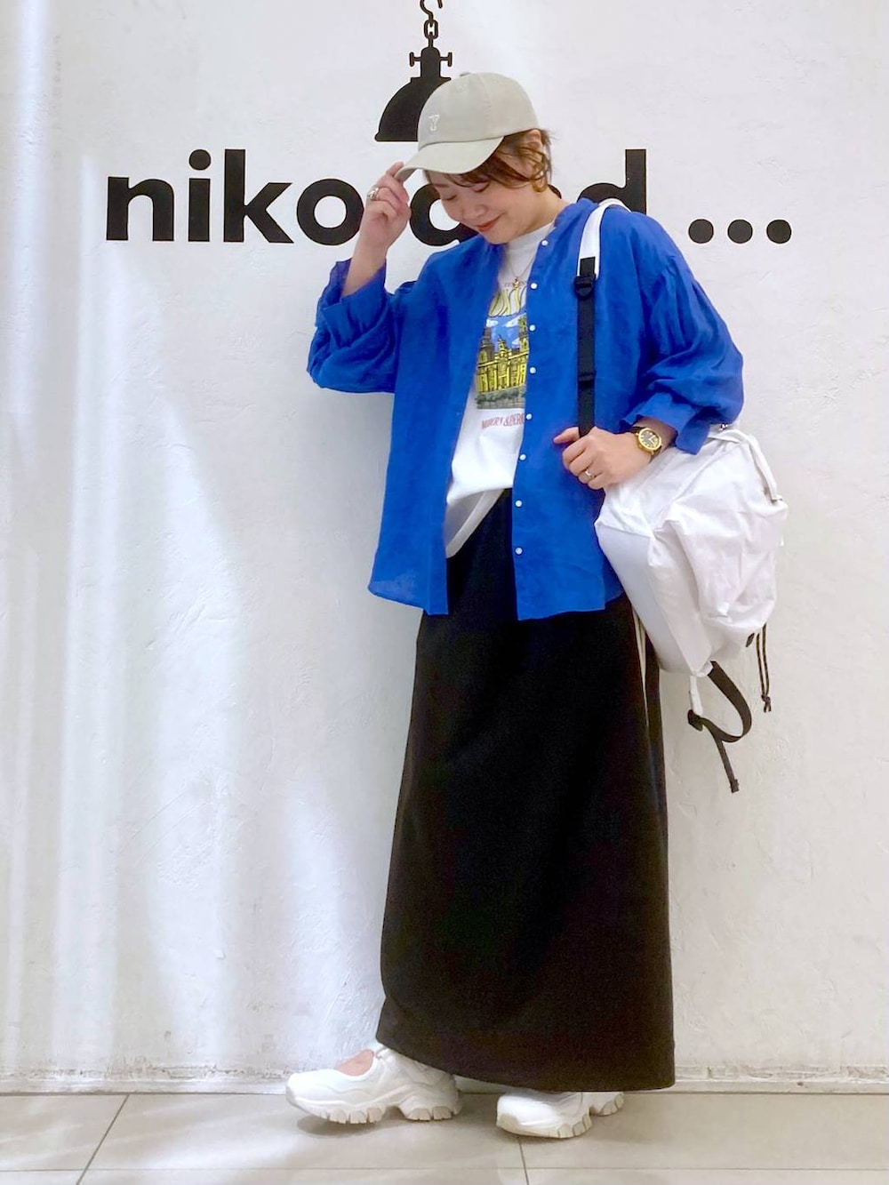 ベージュ系のバックパック/リュック、ホワイト系のTシャツ/カットソー、グレー系のスカートを着用したレディースの春コーディネートの2枚目の写真