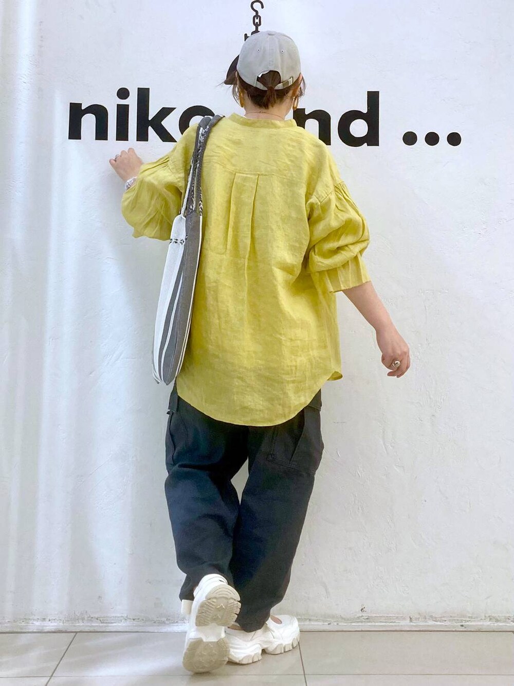 ベージュ系のTシャツ/カットソー、イエロー系のシャツ/ブラウス、グレー系のカーゴパンツを着用したレディースの春コーディネートの4枚目の写真