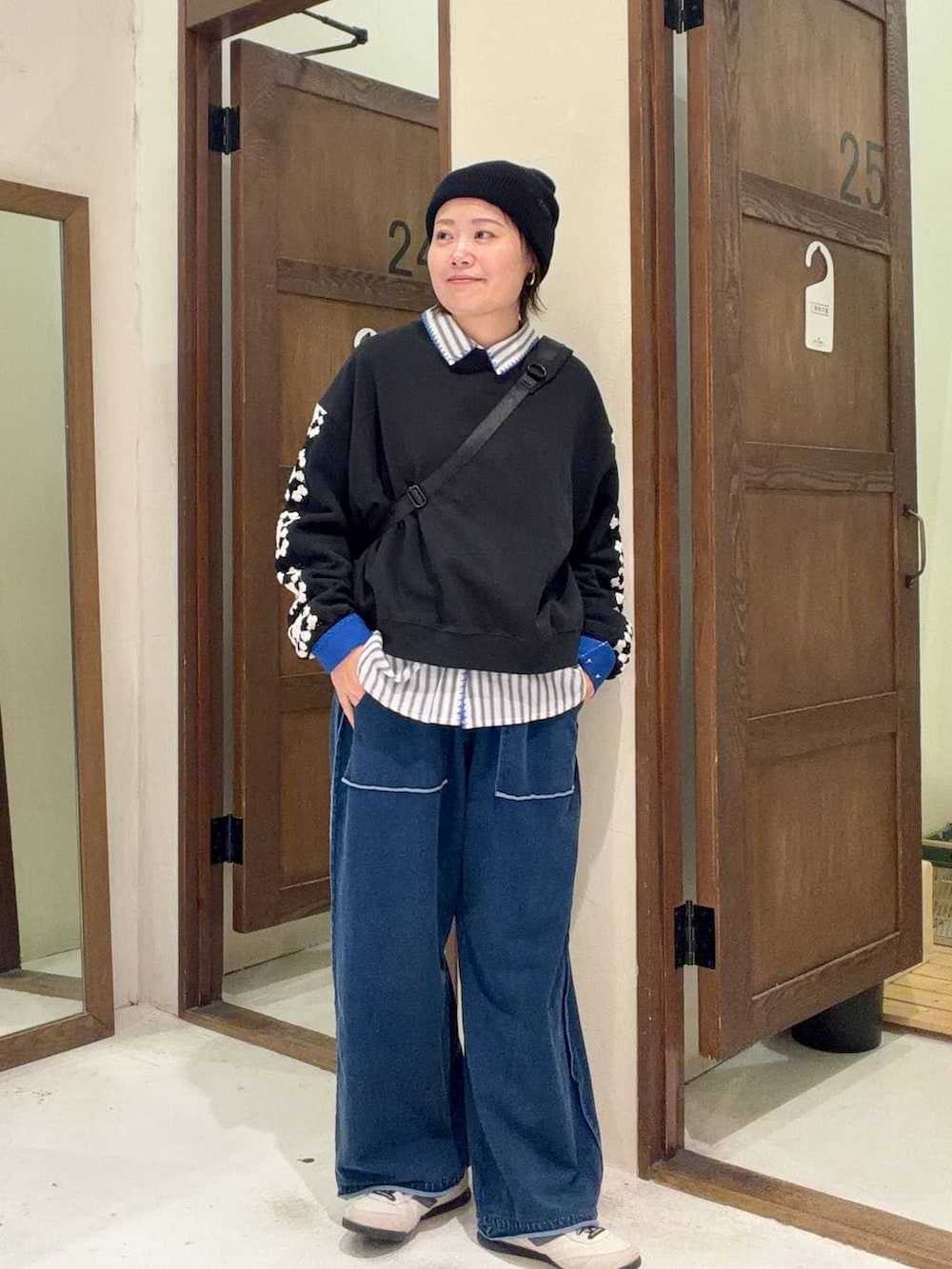 ブラック系のスウェット、ブラック系のショルダーバッグを着用したレディースの冬コーディネートの4枚目の写真