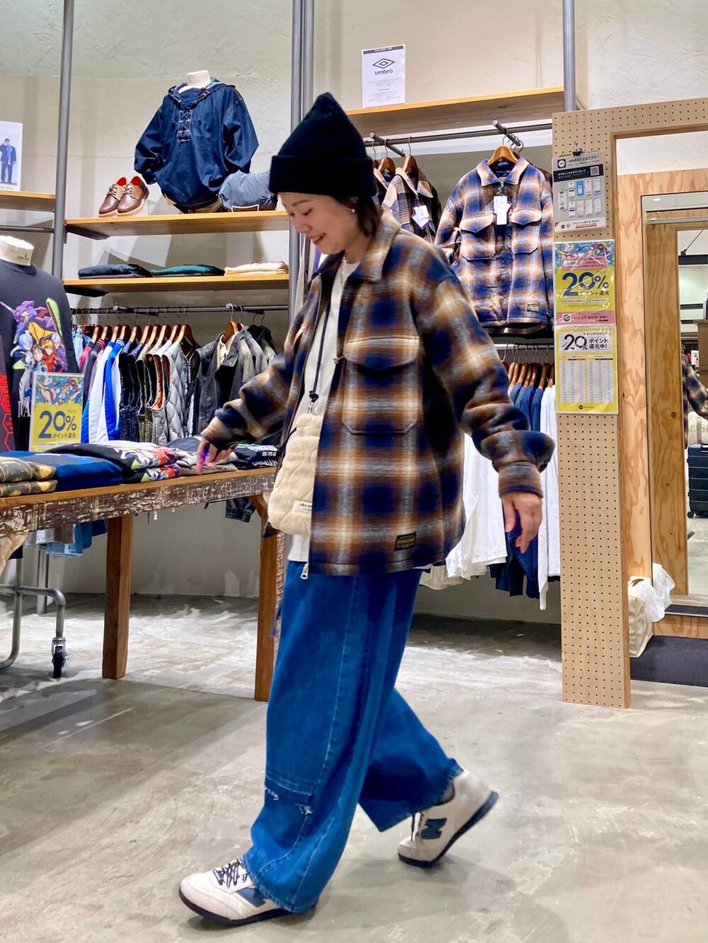 ブルー系のデニムパンツ、ブラウン系のブルゾン、ベージュ系のショルダーバッグを着用したレディースの秋コーディネートの5枚目の写真