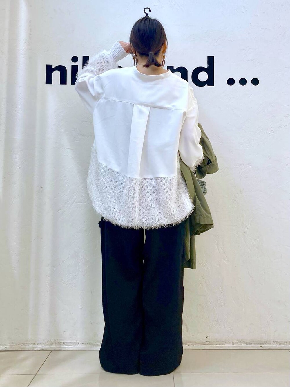 ブラック系のその他パンツ、グリーン系のトレンチコート、ホワイト系のシャツ/ブラウスを着用したレディースの冬コーディネートの5枚目の写真