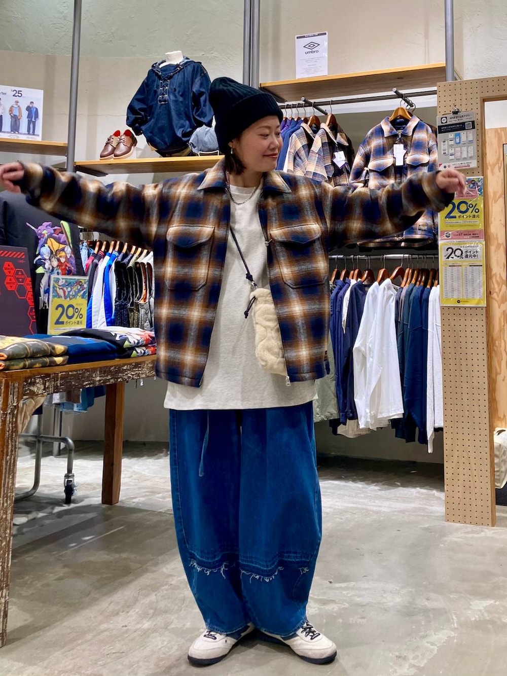 ブルー系のデニムパンツ、ブラウン系のブルゾン、ベージュ系のショルダーバッグを着用したレディースの秋コーディネートの4枚目の写真