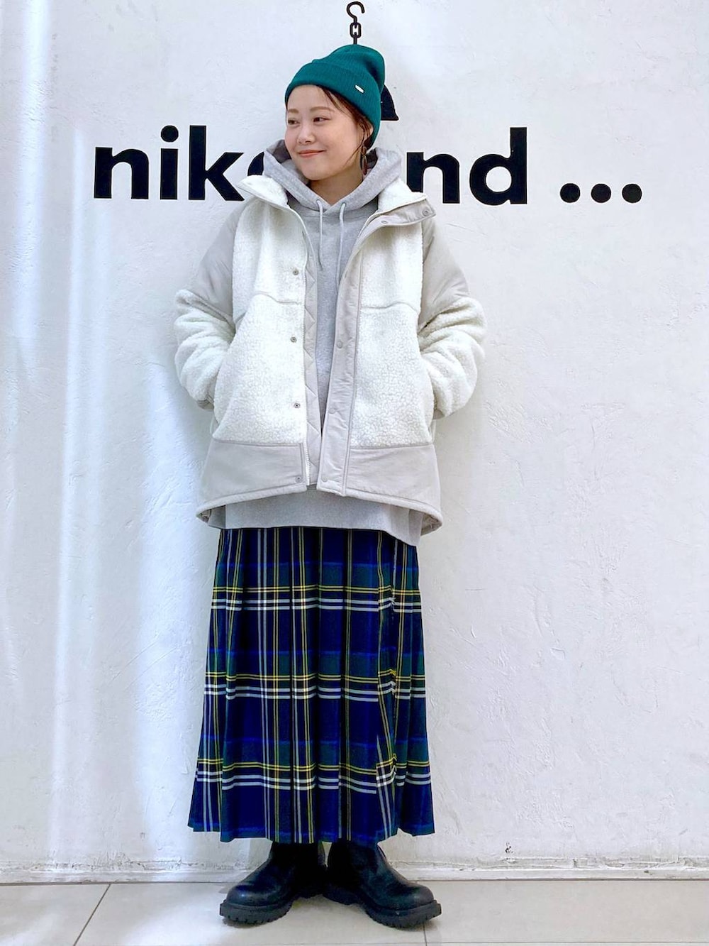 グレー系のパーカー、ベージュ系のブルゾン、ブラウン系のスカートを着用したレディースの秋コーディネートの2枚目の写真