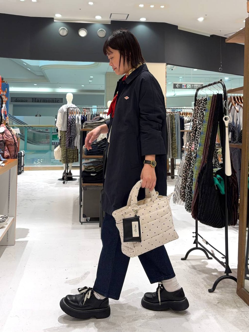 ブラック系のその他シューズ、ホワイト系のトートバッグ、ブルー系のステンカラーコートを着用したレディースの春コーディネートの6枚目の写真