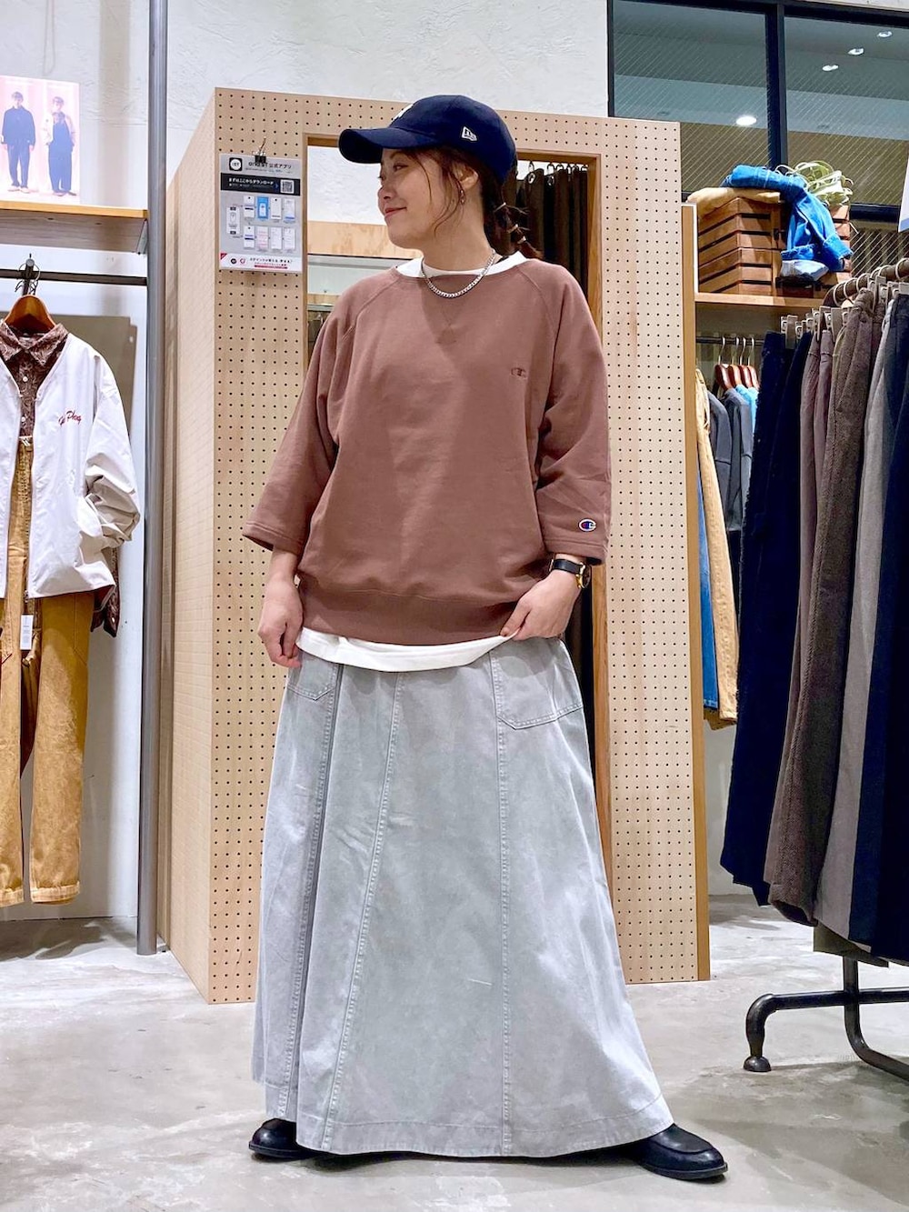 グレー系のスカート、ホワイト系のTシャツ/カットソー、シルバー系のピアス（両耳用）を着用したレディースの春コーディネートの3枚目の写真