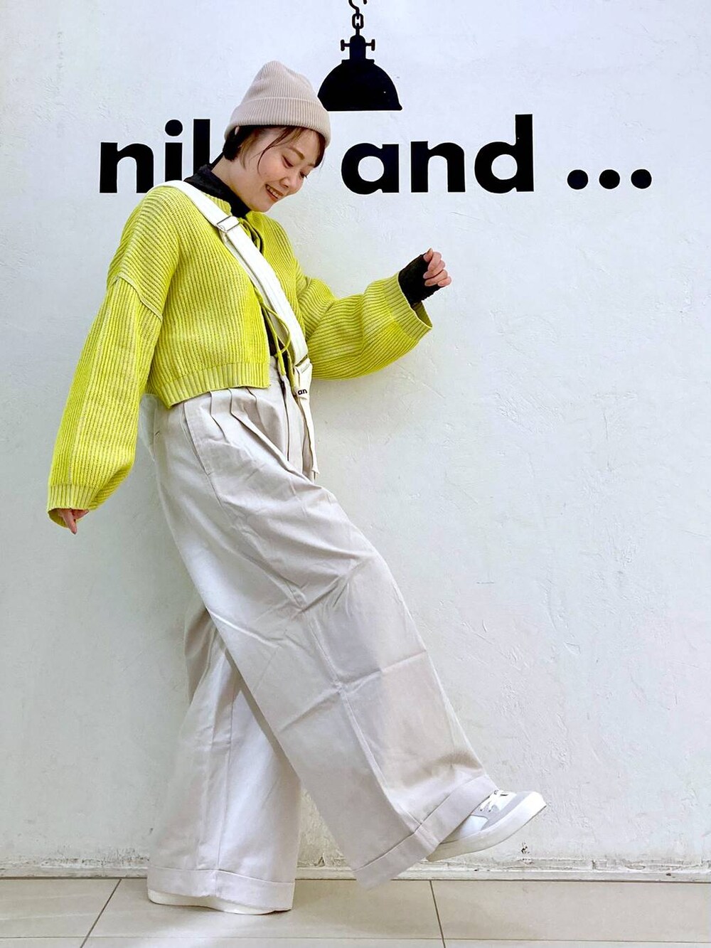 ベージュ系のその他パンツ、イエロー系のニット/セーター、ホワイト系のスニーカーを着用したレディースの冬コーディネートの5枚目の写真
