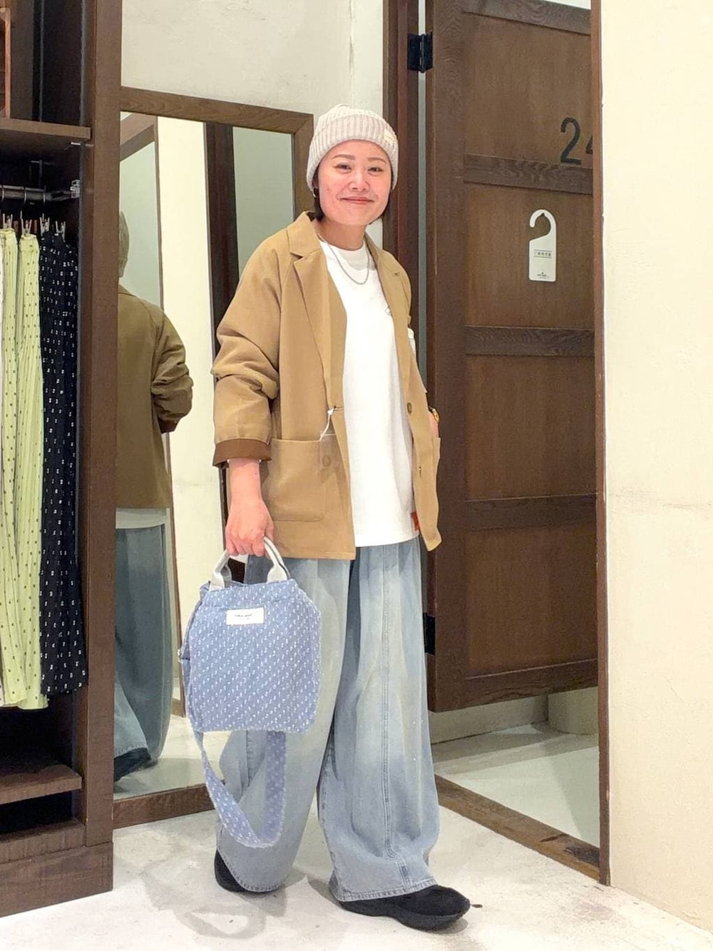 ブルー系のトートバッグ、ブルー系のデニムパンツ、その他のネックレスを着用したレディースの冬コーディネートの2枚目の写真