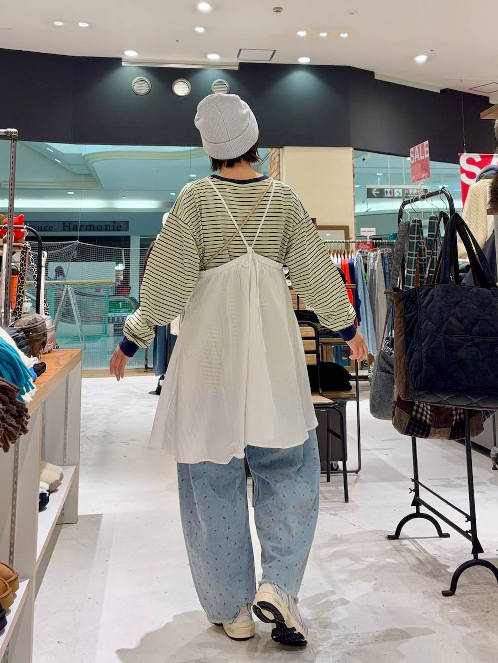 ホワイト系のスニーカー、ブルー系のショルダーバッグ、ブルー系のデニムパンツを着用したレディースの冬コーディネートの3枚目の写真