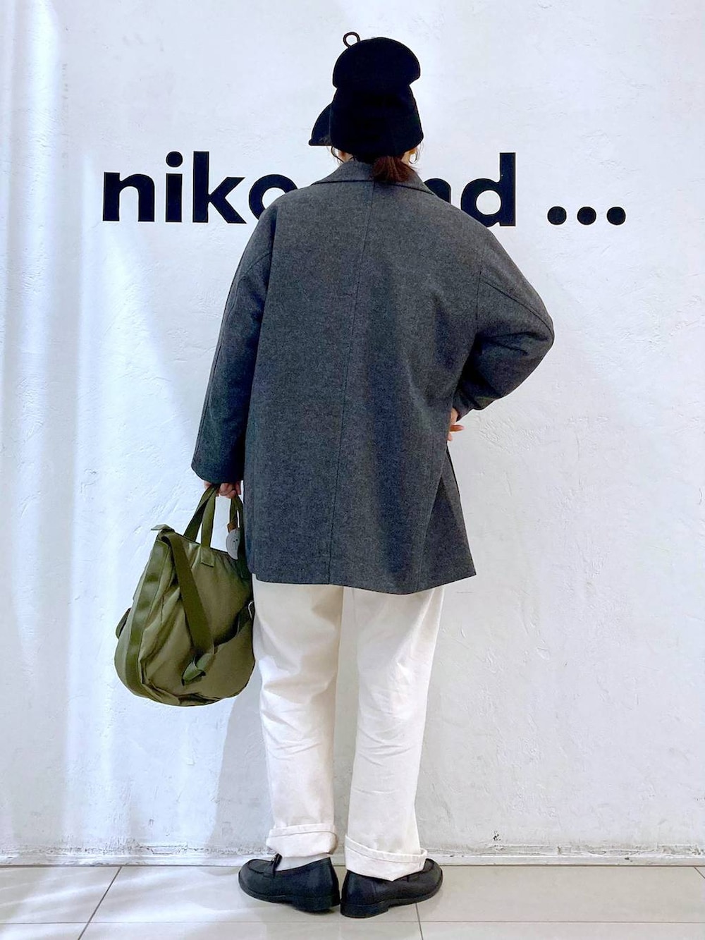 グレー系のテーラードジャケット、ホワイト系のTシャツ/カットソー、グリーン系のトートバッグを着用したレディースの冬コーディネートの4枚目の写真