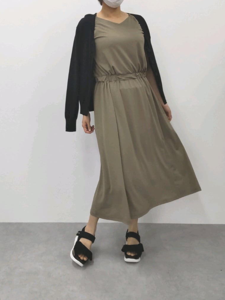 グリーン系のワンピース、ブラック系のカーディガン/ボレロ、ブラック系のサンダルを着用したレディースの夏コーディネートの2枚目の写真