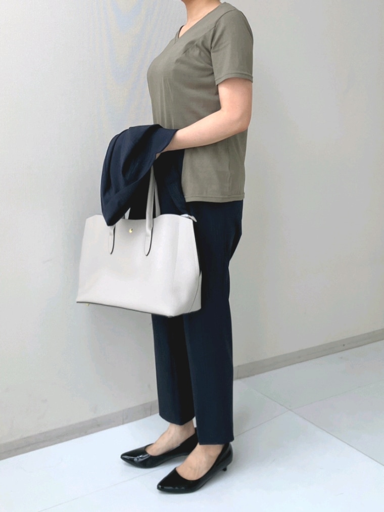 グリーン系のTシャツ/カットソー、ブルー系のスーツセット、ブラック系のパンプスを着用したレディースの春コーディネートの3枚目の写真