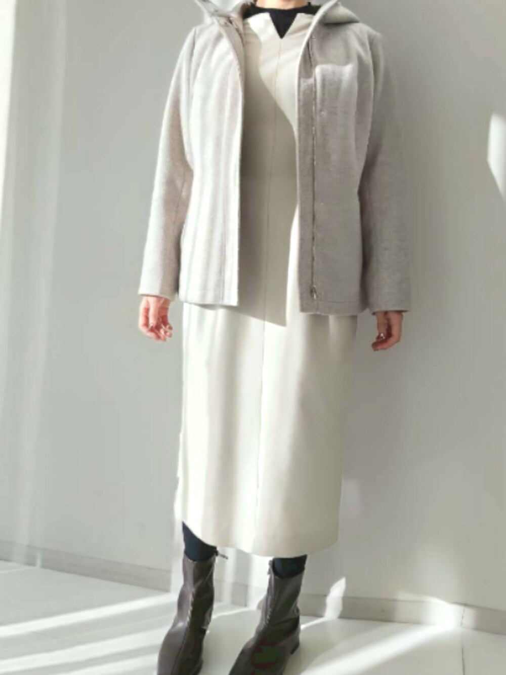 ベージュ系のその他アウター、ベージュ系のワンピース、ブラウン系のブーツを着用したレディースの冬コーディネートの2枚目の写真