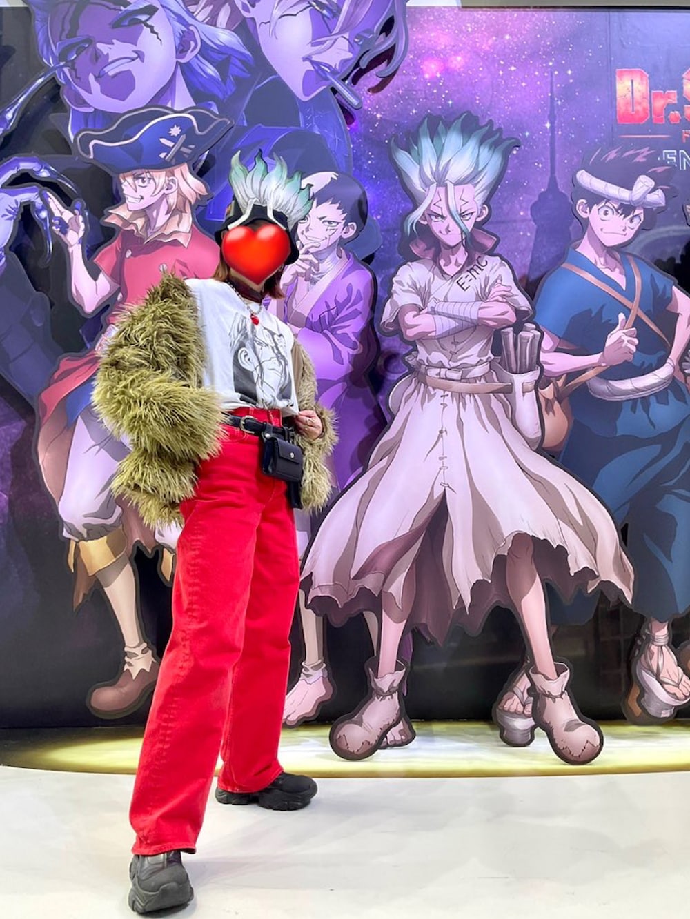 ベージュ系のその他アウター、レッド系のデニムパンツ、ブラック系のブーツを着用したレディースの冬コーディネートの2枚目の写真