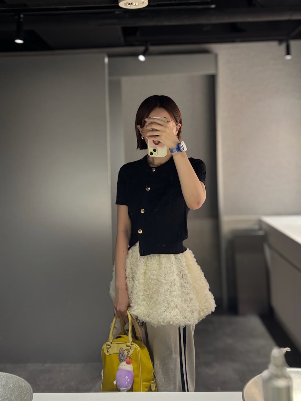 ベージュ系のスウェットパンツ、イエロー系のボストンバッグ、ホワイト系のサンダルを着用したレディースの夏コーディネートの2枚目の写真