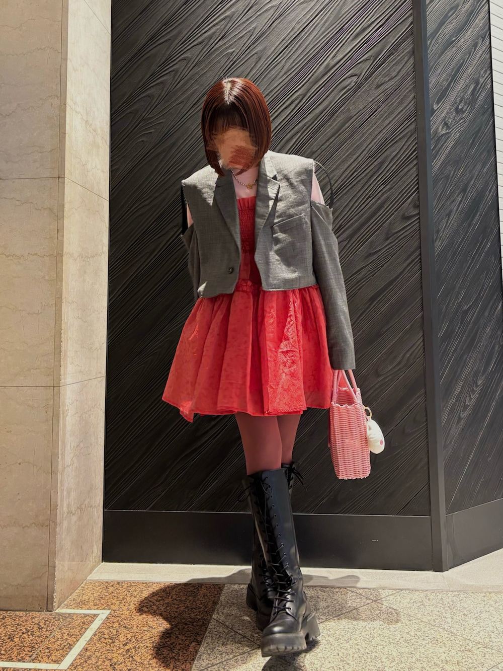 ピンク系のニット/セーター、グレー系のテーラードジャケット、レッド系のワンピース/ドレスを着用したレディースの春コーディネートの2枚目の写真