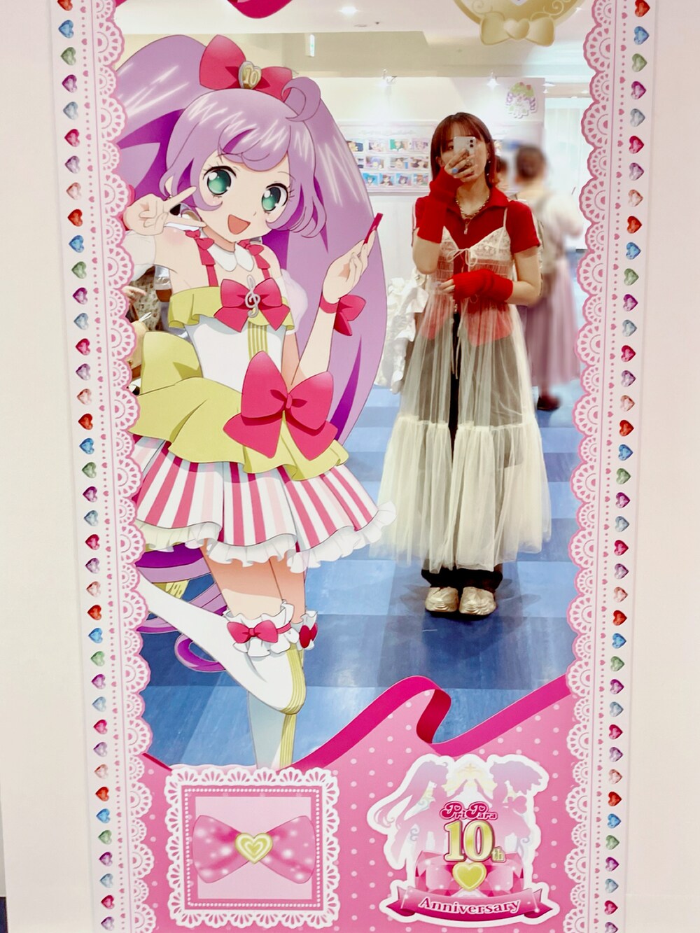 ホワイト系のワンピース、ブラック系のデニムパンツ、ベージュ系のスニーカーを着用したレディースの夏コーディネートの2枚目の写真