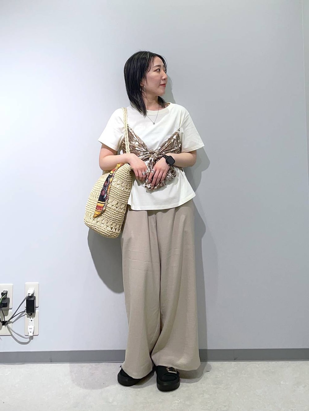 ブラック系のサンダル、ベージュ系のその他パンツ、ベージュ系のトートバッグを着用したレディースの春コーディネートの2枚目の写真