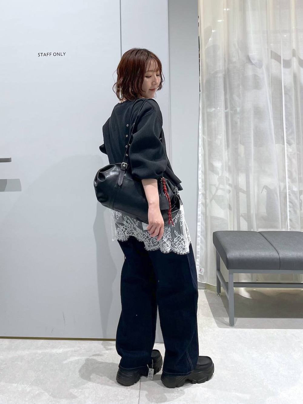 ブルー系のデニムパンツ、ブラック系のボストンバッグ、ブラック系のローファーを着用したレディースの冬コーディネートの4枚目の写真