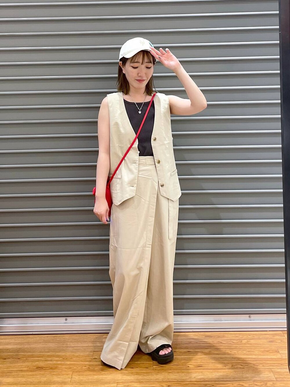 レッド系のショルダーバッグ、ホワイト系のその他パンツ、ホワイト系のベストを着用したレディースの夏コーディネートの3枚目の写真