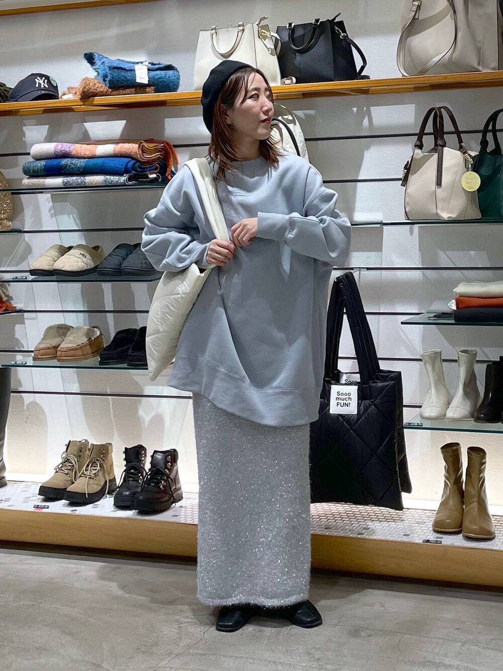 ホワイト系のトートバッグ、シルバー系のスカート、ブルー系のスウェットを着用したレディースの冬コーディネートの2枚目の写真