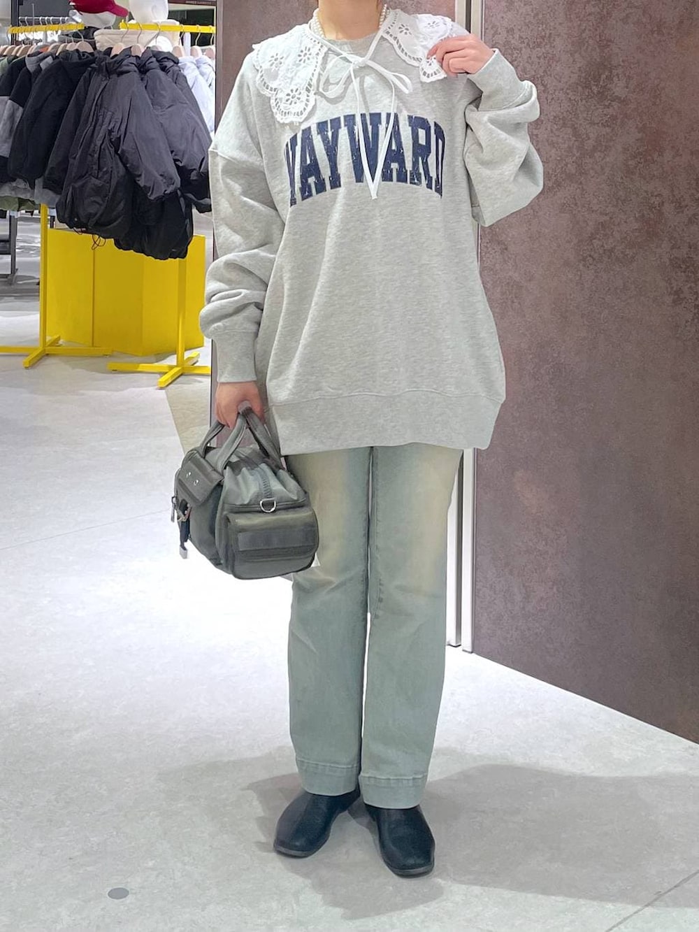グリーン系のボストンバッグ、グレー系のスウェットを着用したレディースの冬コーディネートの2枚目の写真